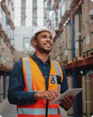 A man smiling at his stock in a warehouse