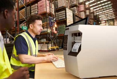 A warehouse operative working on his computer to print a barcode