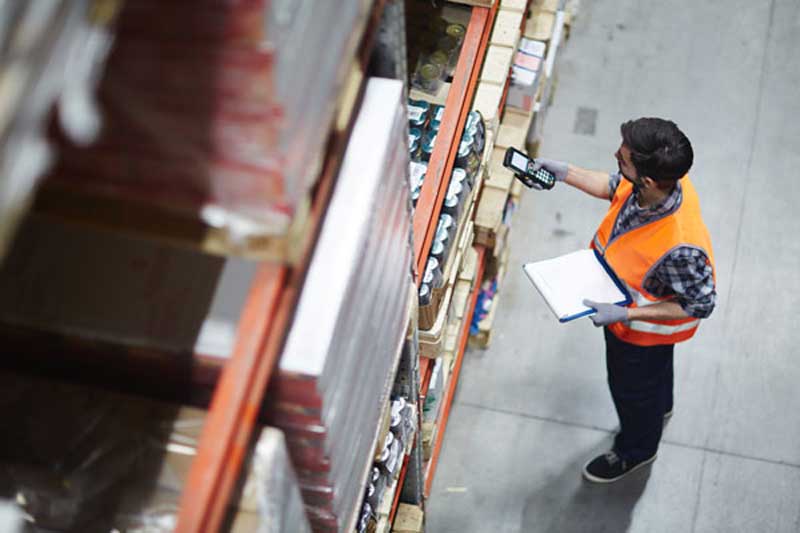 A man scanning a warehouse
