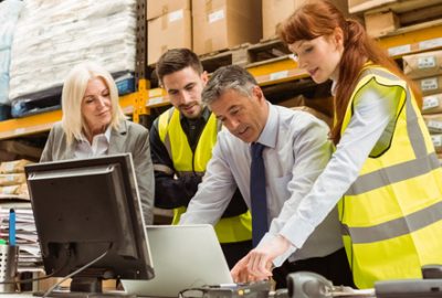 warehouse managers looking at computers having a meeting